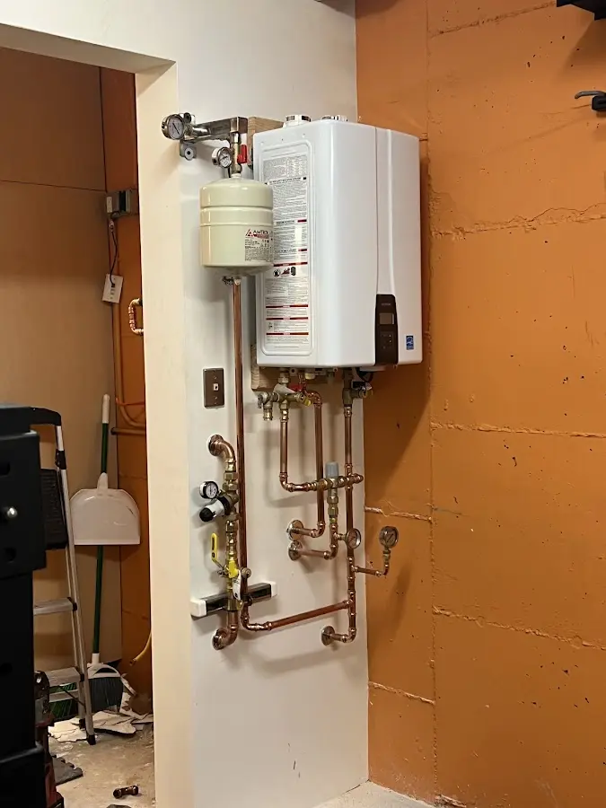 Plumbing technician inspecting water heater connections in Ebensburg